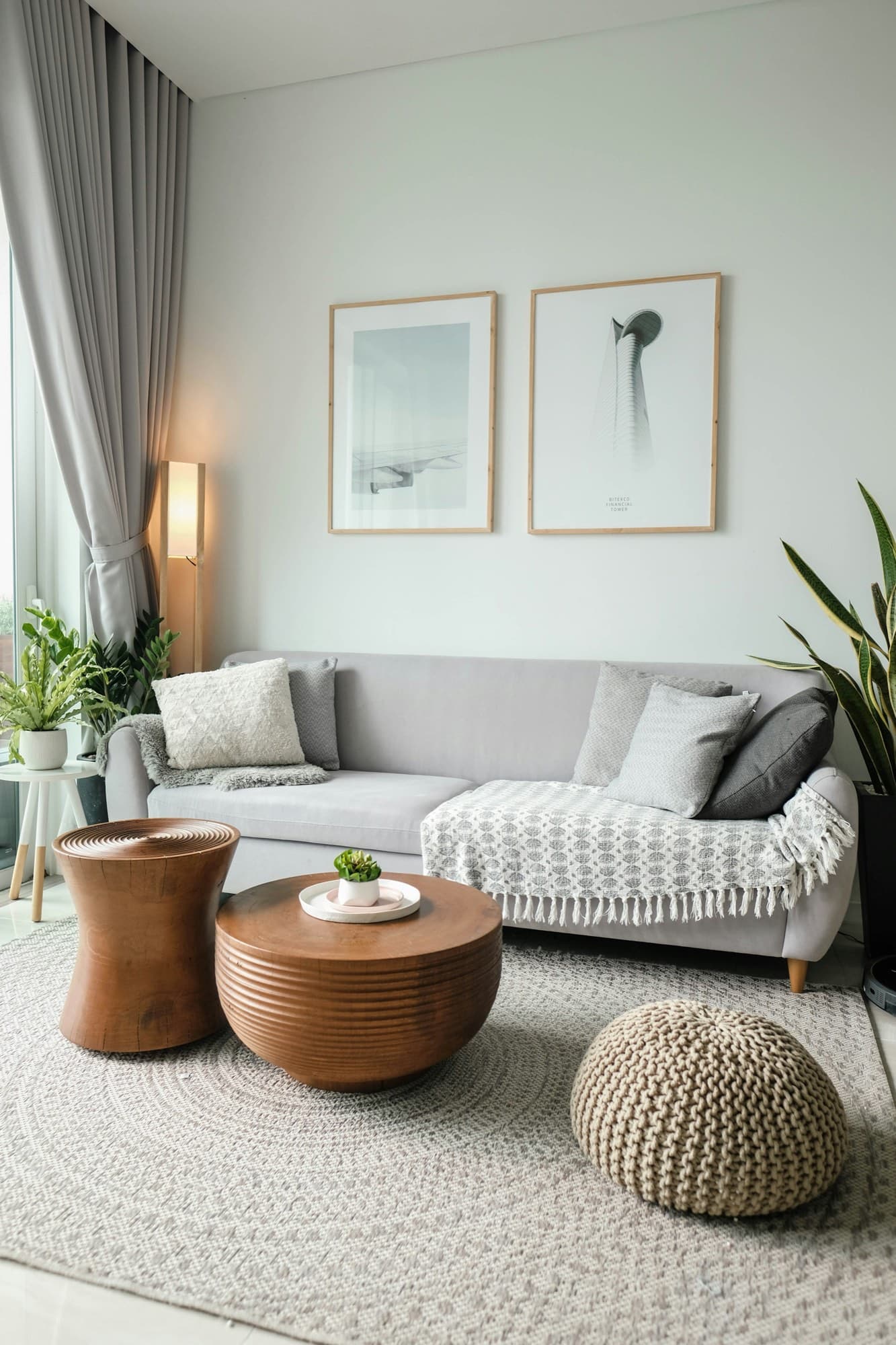 Tidy living room with a grey sofa, woven rug and plants